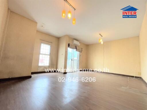 Spacious living room with hardwood floors and large windows.