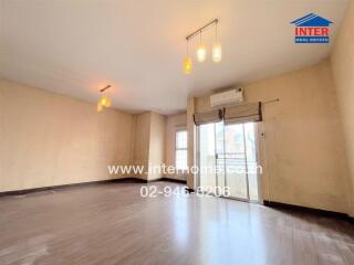 Spacious living room with wooden flooring and large windows