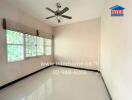 Vacant bedroom with large window and ceiling fan