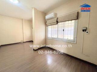 Spacious living room with wooden flooring and large window