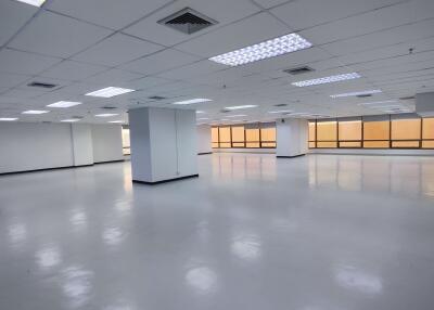 Spacious empty office with large windows and overhead lighting