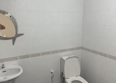 Modern bathroom with white tiles, toilet, and sink