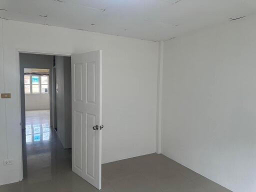 Empty bedroom with an open door leading to another room