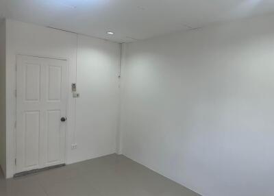 Empty room with white walls, door, and minimal lighting