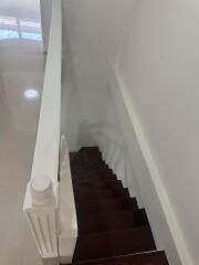 View of staircase with wooden steps and white railings