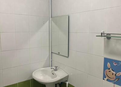 Small bathroom with a sink, mirror, and tiled walls