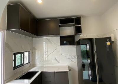 Modern kitchen with dark cabinets and large refrigerator