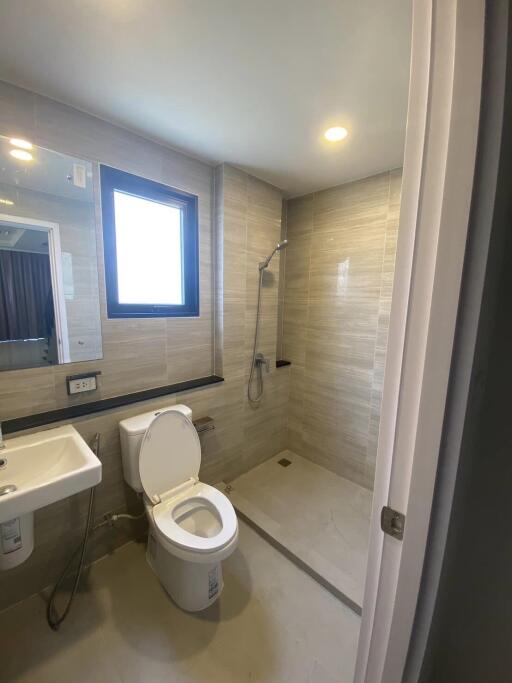 Modern bathroom with toilet, sink, and walk-in shower