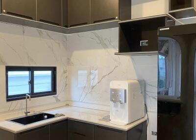 Modern kitchen with dark cabinetry and marble backsplash