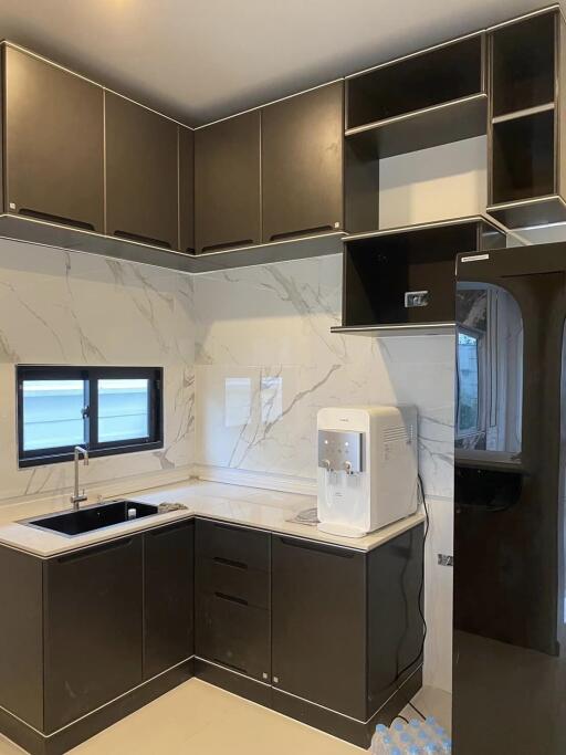 Modern kitchen with dark cabinetry and marble backsplash