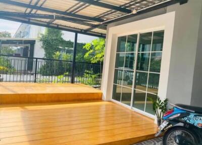 Spacious patio area with wooden flooring and a sliding glass door