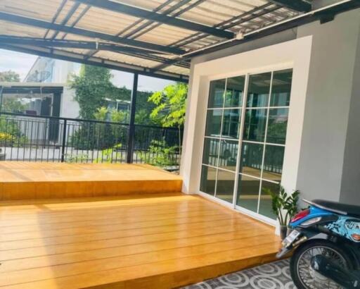 Spacious patio area with wooden flooring and a sliding glass door