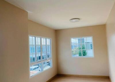 Bright empty bedroom with windows and wooden flooring