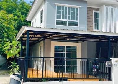 Modern two-story house with a gated fence and a carport.