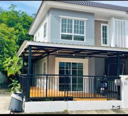 Modern two-story house with a gated fence and a carport.