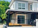 Modern two-story house with a gated fence and a carport.