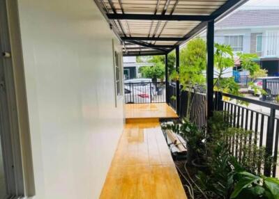 Covered outdoor walkway with garden view in residential area.