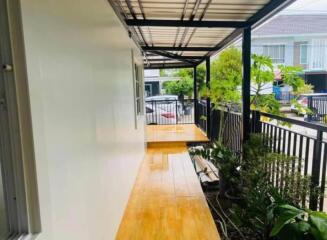 Covered outdoor walkway with garden view in residential area.