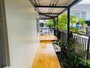 Covered outdoor walkway with garden view in residential area.