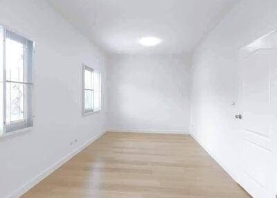 Spacious empty room with wooden floors and windows