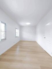 Spacious empty room with wooden floors and windows