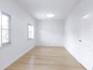 Spacious empty room with wooden floors and windows