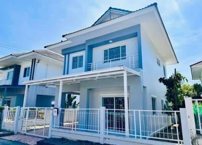 Two-story modern house with white fence and carport