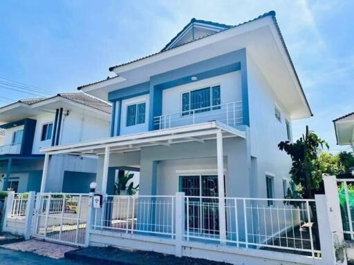 Two-story modern house with white fence and carport