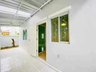 Covered outdoor area next to a white building with large windows and a door