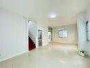 spacious and well-lit living room with staircase