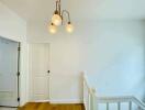 Hallway with pendant lights and white walls