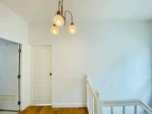 Hallway with pendant lights and white walls