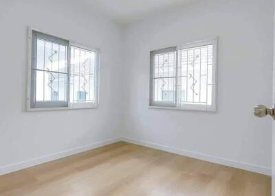 Bright bedroom with wooden flooring and windows