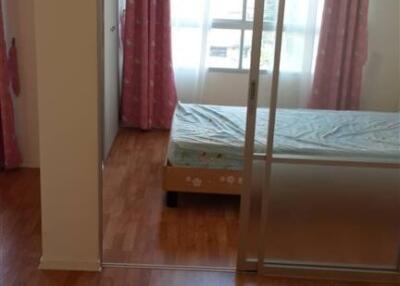 Bedroom with wooden flooring, large window, and pink curtains