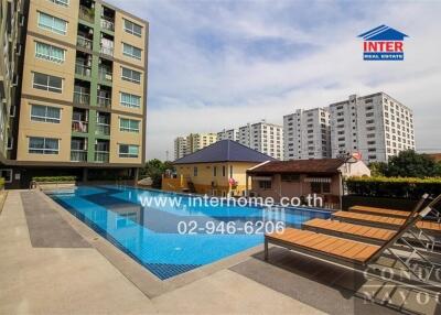 Modern apartment building with swimming pool and lounge chairs