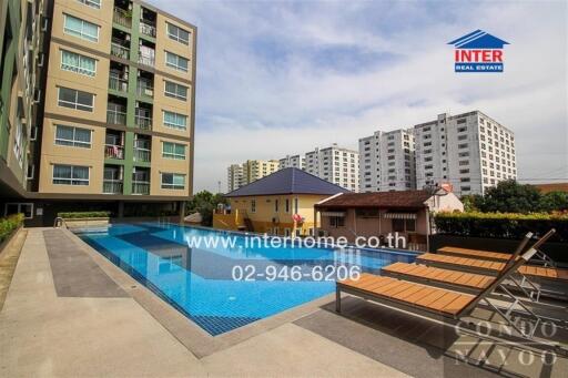 Modern apartment building with swimming pool and lounge chairs