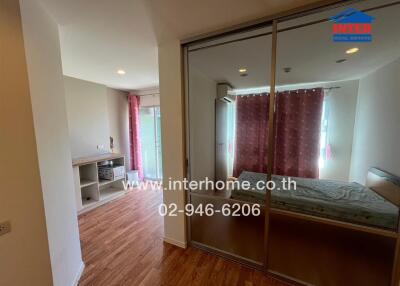 Modern bedroom with glass sliding door, wooden floors, and a pink curtain.