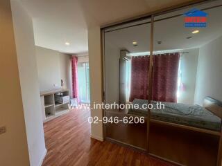 Modern bedroom with glass sliding door, wooden floors, and a pink curtain.