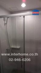 Shower area with glass door and wall-mounted showerhead