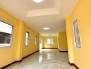 Spacious and bright hallway with yellow walls and large windows