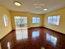 spacious living room with large windows and wooden flooring