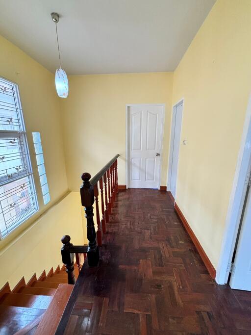 Bright hallway with wooden parquet flooring and large window