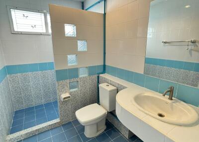 Modern bathroom with shower area, vanity, and toilet