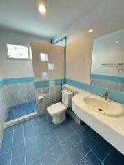 Modern bathroom with shower area, vanity, and toilet