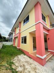 Exterior view of a two-story house with yellow and pink walls