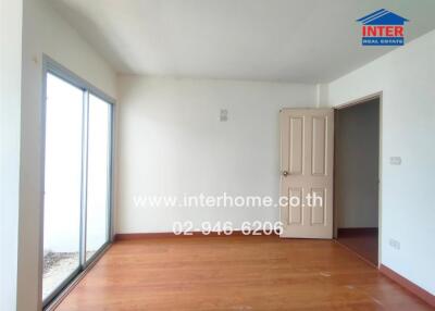 Empty bedroom with wooden floor and large sliding glass door