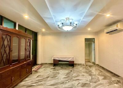 Spacious living room with marble floors and chandelier