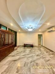 Spacious living room with marble floors and chandelier