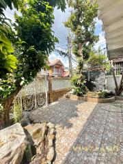 House outdoor area with tiled patio, gate, and greenery