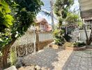 House outdoor area with tiled patio, gate, and greenery